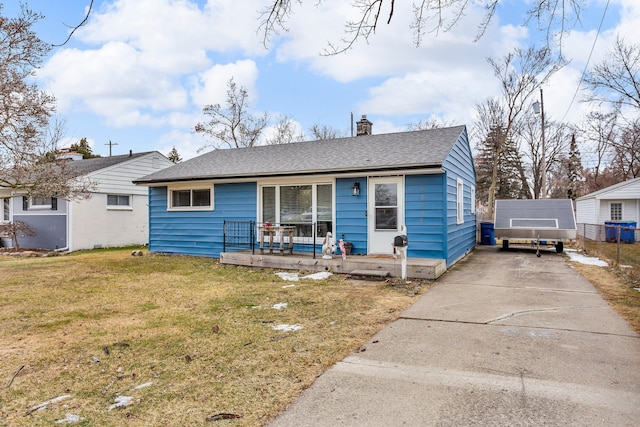 view of front of home with an outbuilding, covered porch, and a front yard