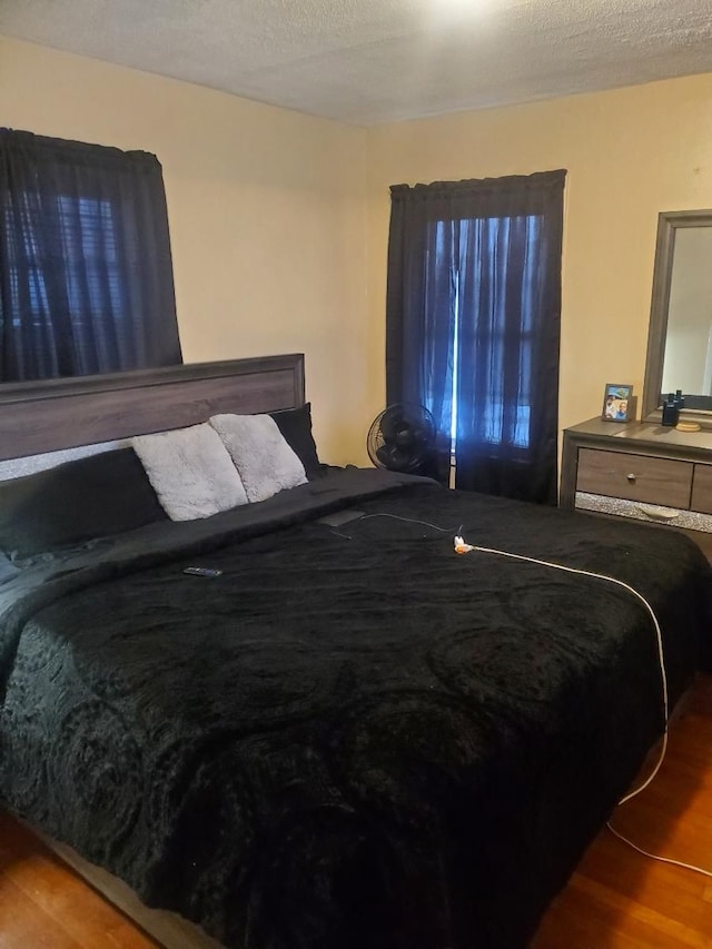 bedroom featuring hardwood / wood-style flooring and a textured ceiling