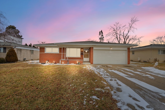 single story home with a garage and a lawn