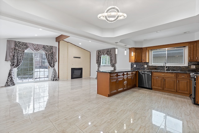 kitchen with decorative light fixtures, kitchen peninsula, dark stone counters, and appliances with stainless steel finishes