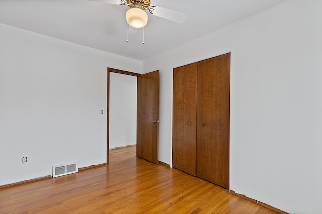 unfurnished bedroom with ceiling fan, a closet, and light hardwood / wood-style flooring