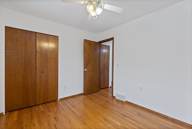 unfurnished bedroom with light hardwood / wood-style floors, a closet, and ceiling fan