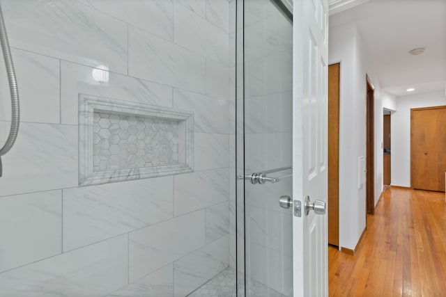 bathroom featuring hardwood / wood-style floors and a shower with door