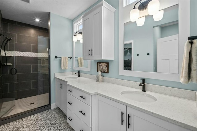 full bathroom with a stall shower, tile patterned flooring, a sink, and double vanity