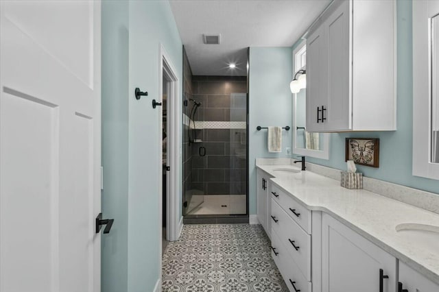 bathroom featuring double vanity, a shower stall, visible vents, and a sink