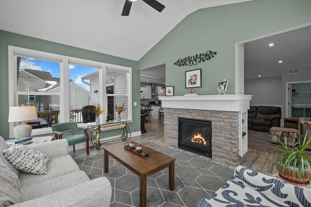 living room with high vaulted ceiling, visible vents, a fireplace, and ceiling fan