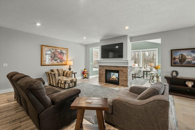 living room featuring recessed lighting, a fireplace, baseboards, and wood finished floors