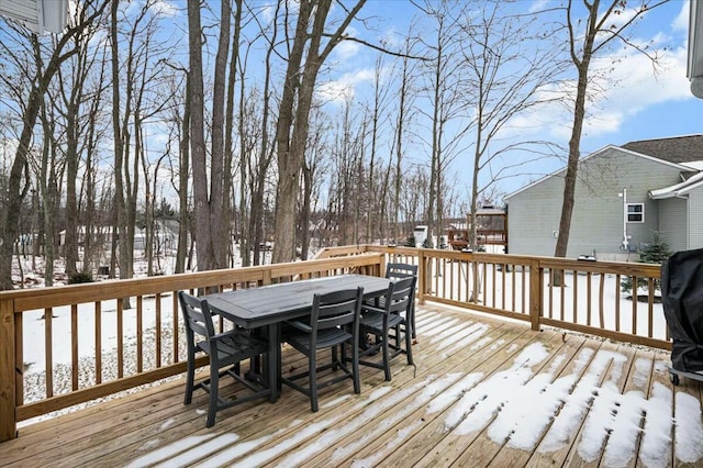 snow covered deck featuring outdoor dining area