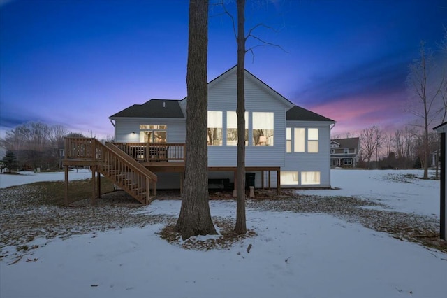 snow covered property with a deck and stairway