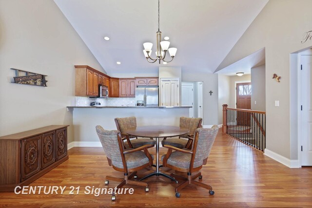 100 Tuscany Cir, Saginaw, MI 48603 - dining area featuring vaulted ceiling, a chandelier, light wood finished floors, and baseboards