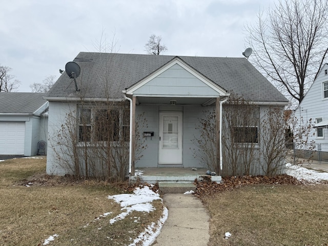 view of front facade featuring a front yard and roof with shingles