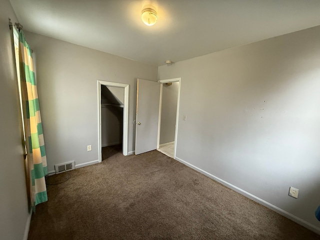 unfurnished bedroom featuring carpet, a closet, visible vents, and baseboards