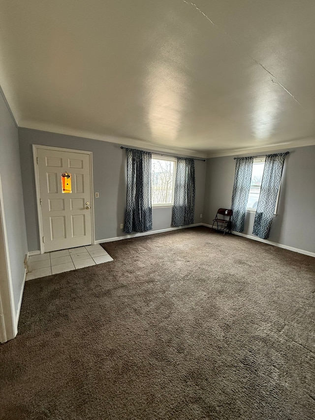 unfurnished living room featuring carpet floors and baseboards