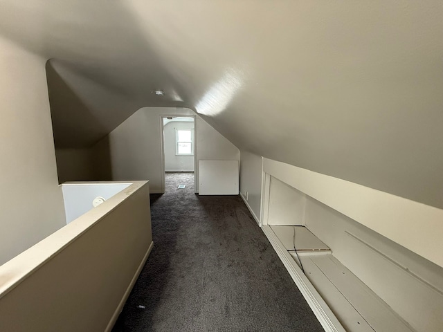 bonus room featuring dark colored carpet and lofted ceiling