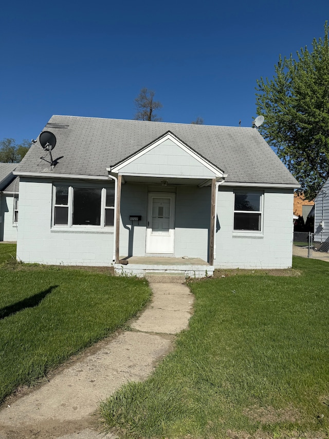 5727 Merriman Rd, Garden City, MI 48135 - view of front of property with concrete block siding, a front yard, a porch, and roof with shingles