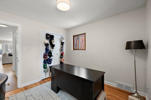 home office with crown molding and wood-type flooring