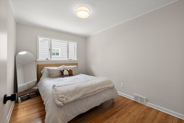 bedroom featuring hardwood / wood-style flooring and ornamental molding