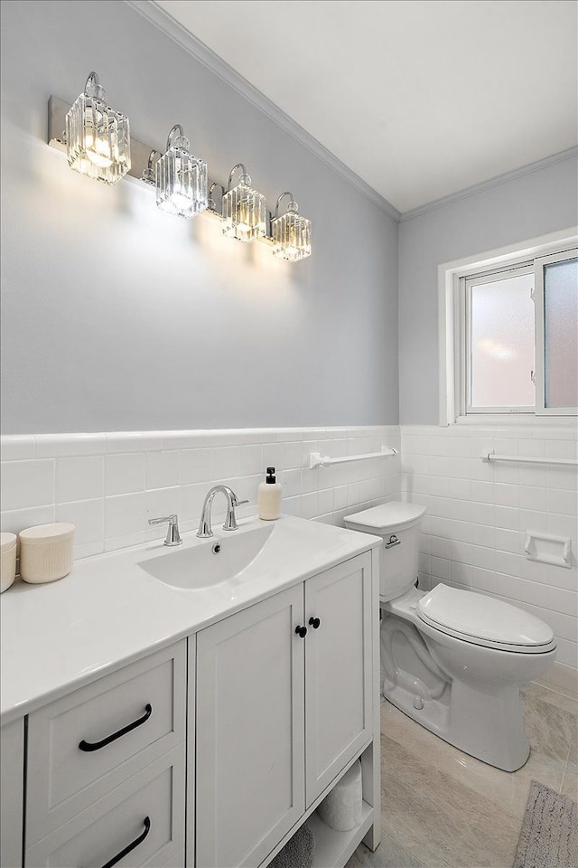 bathroom featuring tile walls, vanity, crown molding, and toilet