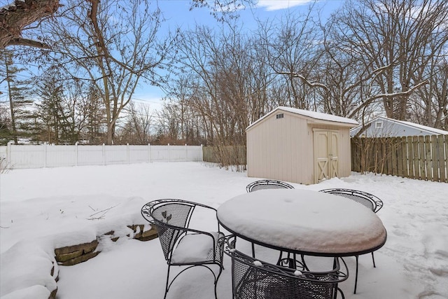 yard covered in snow with a storage unit