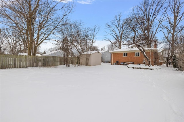 yard covered in snow with a shed