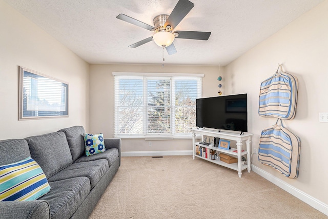 carpeted living room with ceiling fan and a textured ceiling