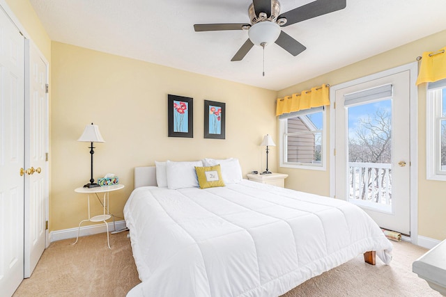 bedroom with access to exterior, light colored carpet, and ceiling fan