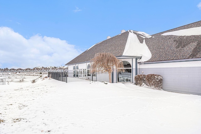 view of snow covered back of property