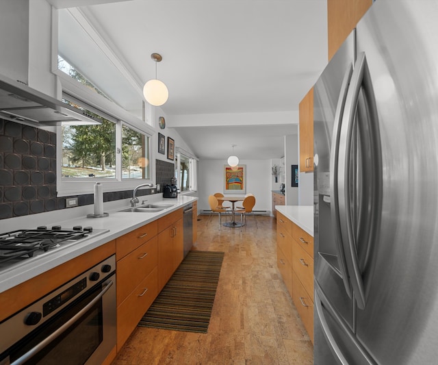 kitchen featuring pendant lighting, lofted ceiling, appliances with stainless steel finishes, and sink