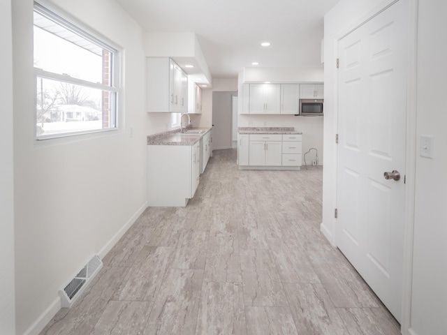 kitchen featuring white cabinetry and sink