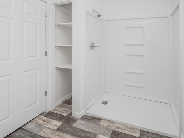 bathroom with hardwood / wood-style flooring and a shower