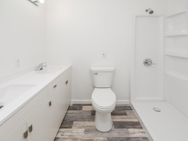 bathroom with vanity, hardwood / wood-style floors, walk in shower, and toilet