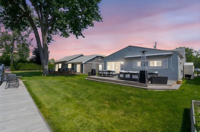 rear view of property featuring a yard and outdoor lounge area