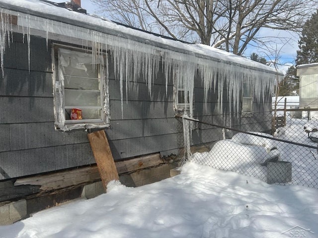 snow covered property featuring fence