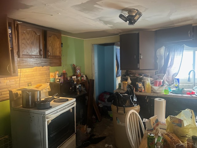 kitchen featuring brown cabinetry, electric range, and decorative backsplash