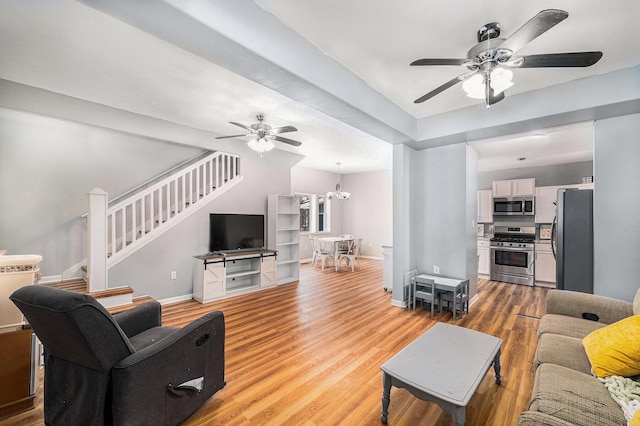 living room featuring wood-type flooring and ceiling fan