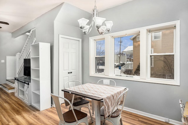 dining area featuring hardwood / wood-style flooring and an inviting chandelier