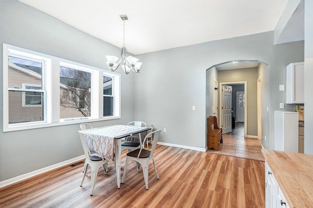 dining space with a notable chandelier and light hardwood / wood-style floors