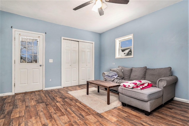 living room with dark hardwood / wood-style flooring and ceiling fan