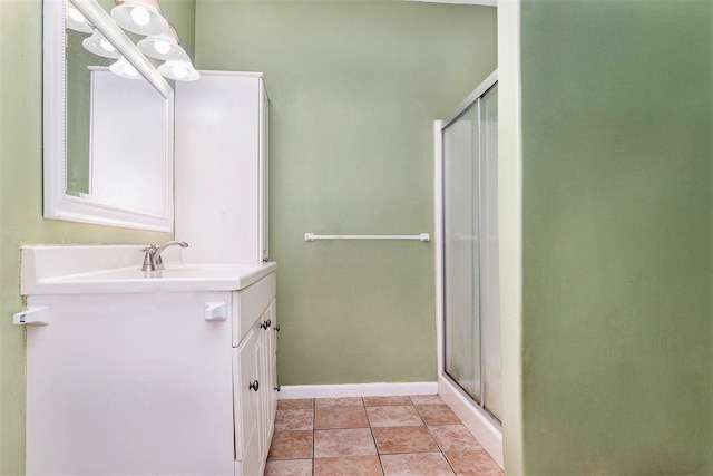 bathroom with a shower with door, vanity, and tile patterned flooring