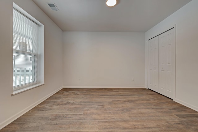 unfurnished bedroom with wood-type flooring and a closet