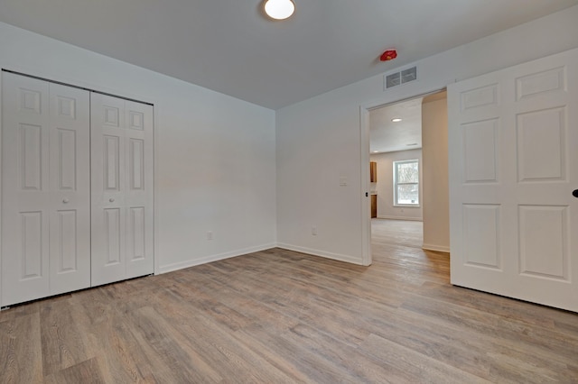 unfurnished bedroom with light hardwood / wood-style floors and a closet