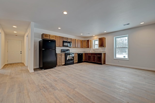 kitchen featuring sink, light hardwood / wood-style floors, and black appliances