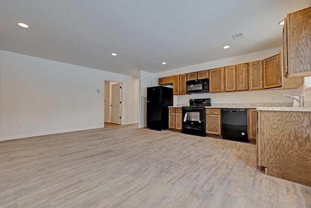 kitchen featuring sink, light wood-type flooring, and black appliances