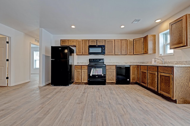 kitchen with sink, light hardwood / wood-style floors, and black appliances