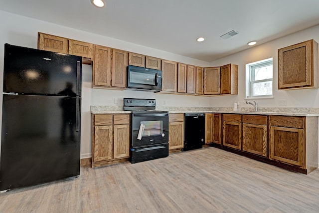 kitchen featuring light hardwood / wood-style flooring and black appliances