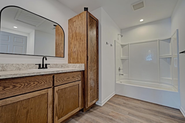 bathroom featuring vanity, wood-type flooring, and bathtub / shower combination