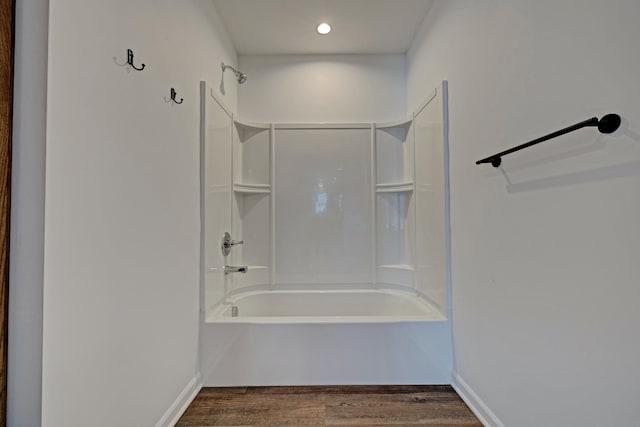 bathroom with hardwood / wood-style flooring and tub / shower combination