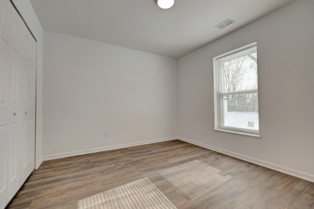 unfurnished bedroom with hardwood / wood-style floors and a closet