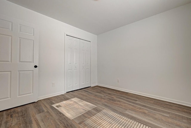 unfurnished bedroom featuring wood-type flooring and a closet