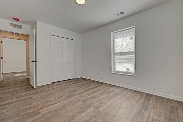 unfurnished bedroom featuring wood-type flooring and a closet